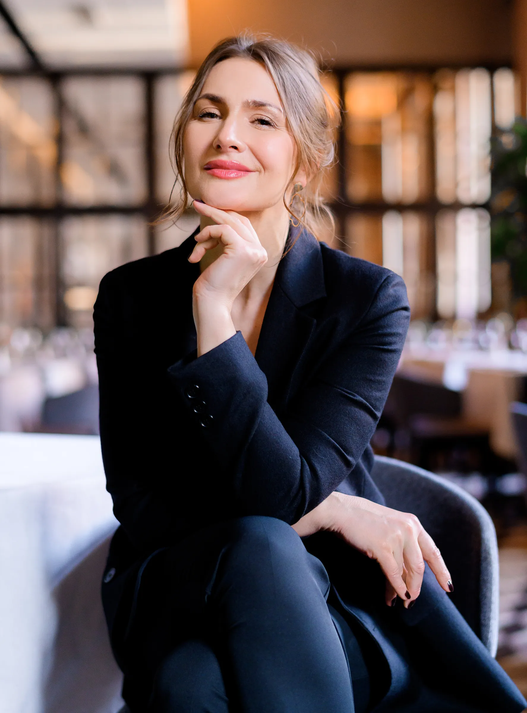 Een zelfzekere zaakvoerder in een donker pak, zittend in een restaurant